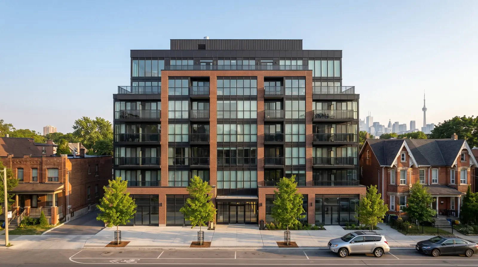 The Clinton, a finished 8-storey brick and glass condominium on a tree-lined Toronto street